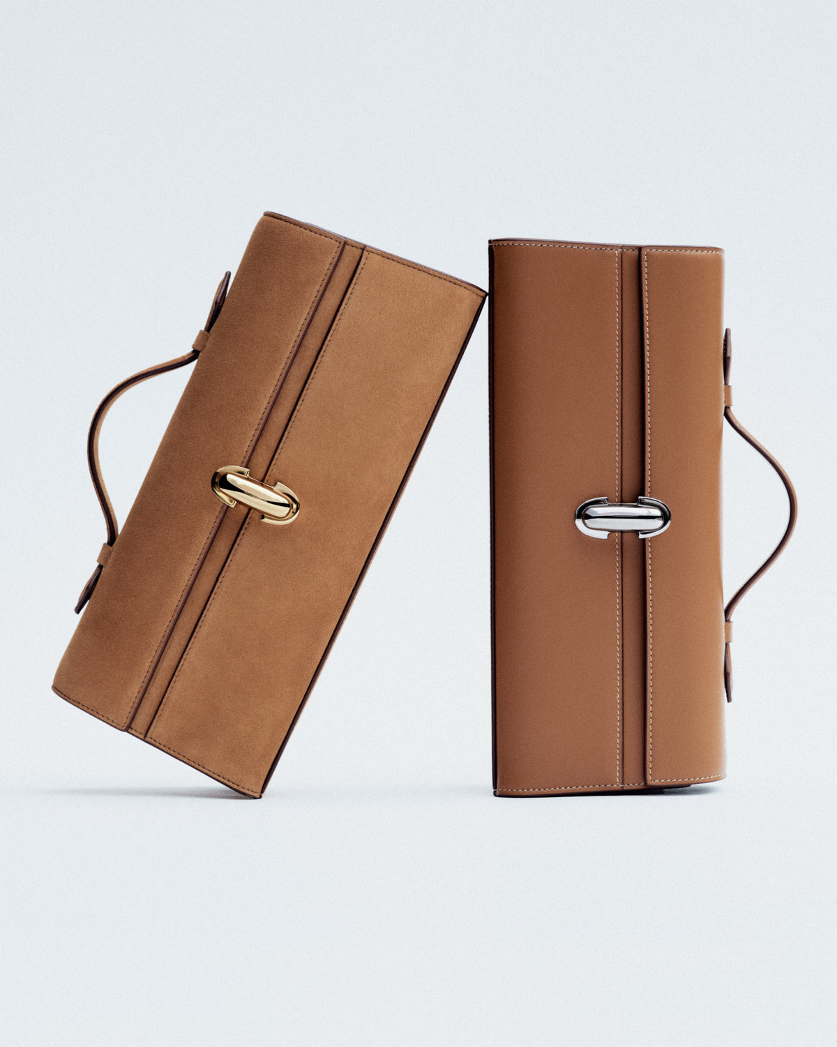 campaign image of two saddle brown leather bags with gold clasps on a white background