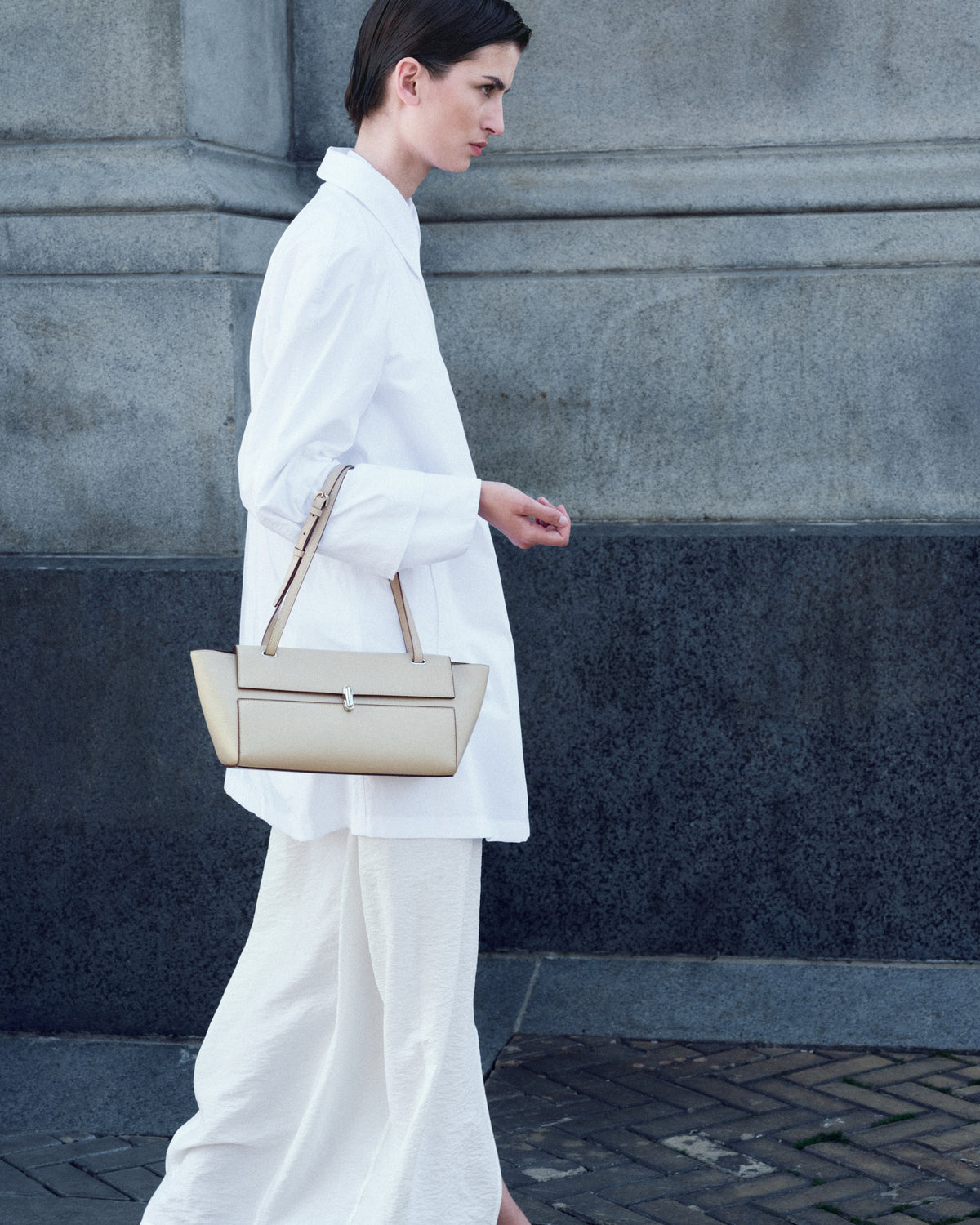 campaign on model image of a bone beige leather bag with silver clasp