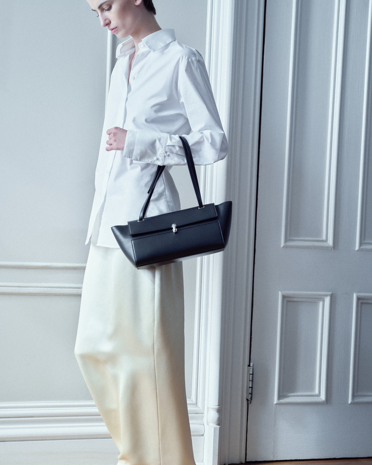 campaign on model image of a black leather bag with silver clasp