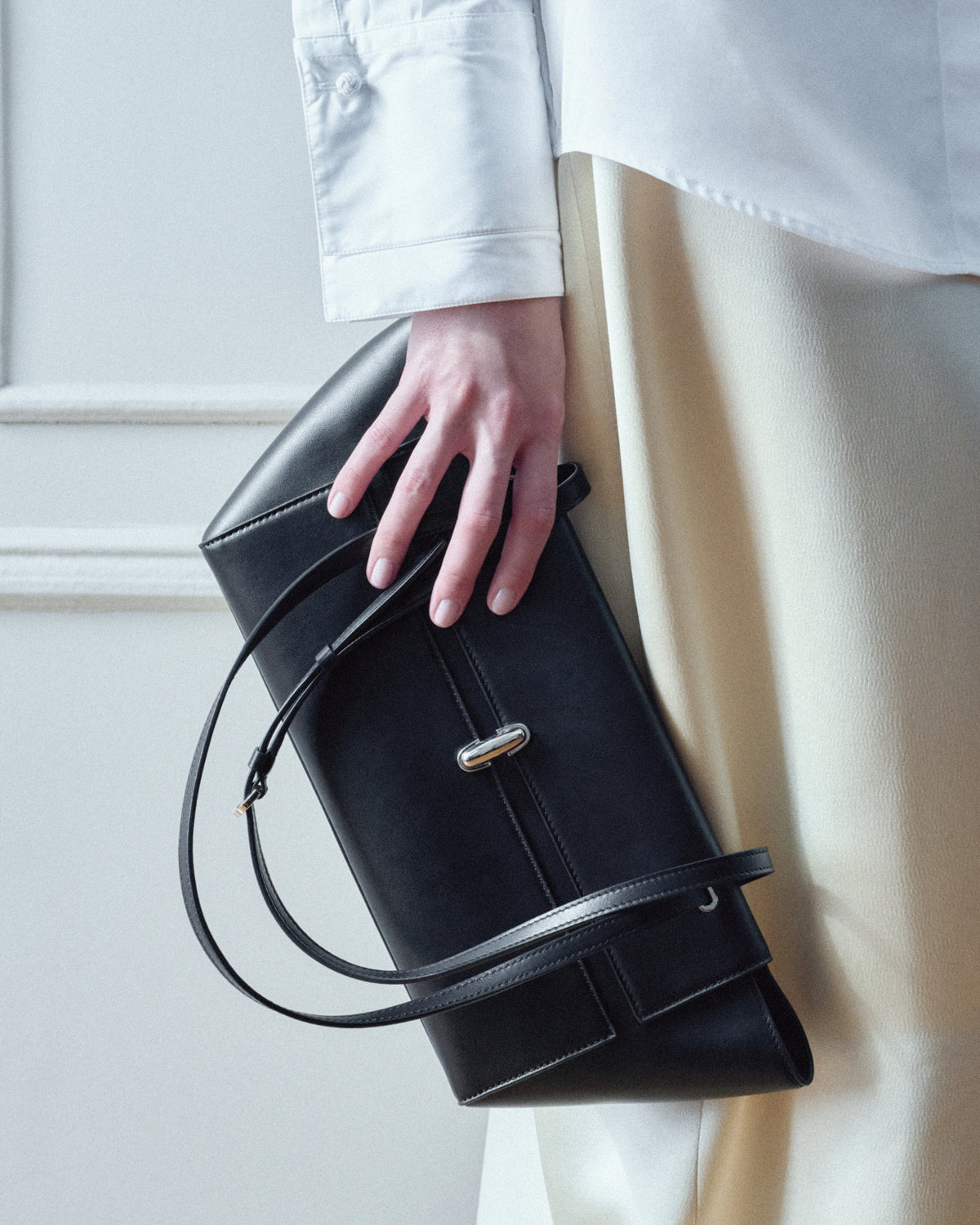 campaign on model image of a black leather bag with silver clasp
