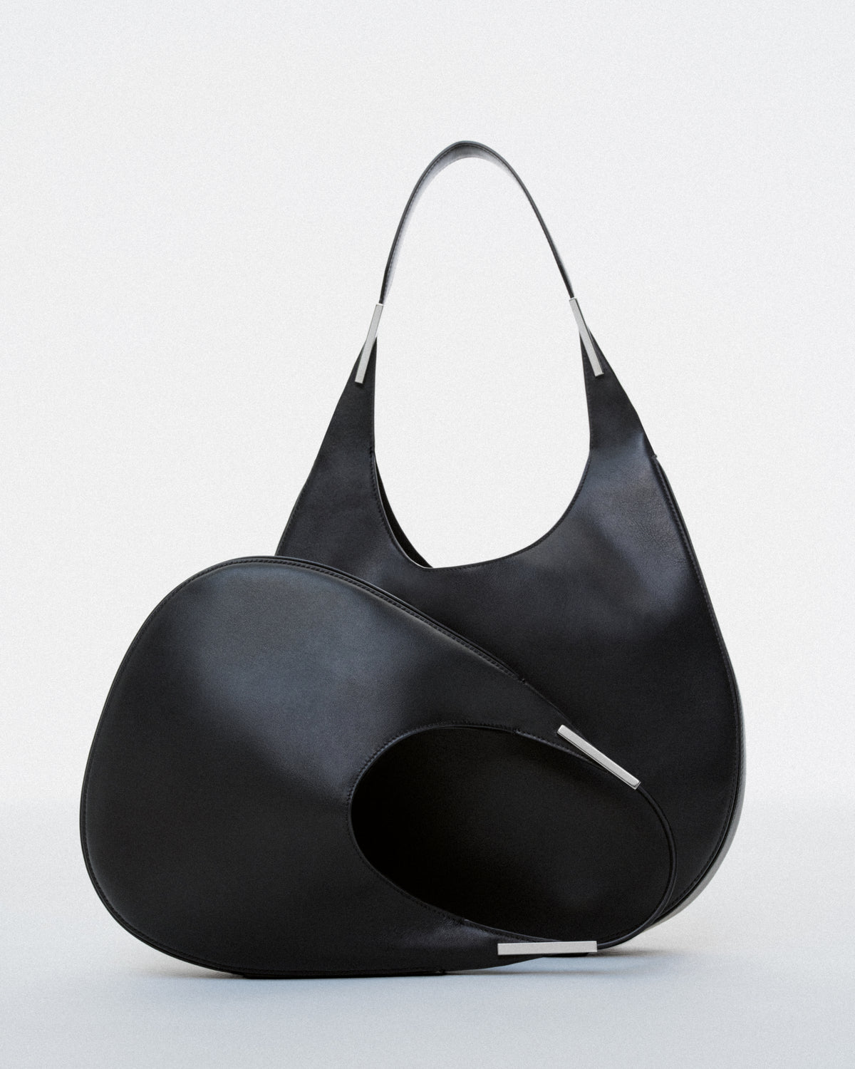 campaign image of two black leather bags with silver hardware on a white background