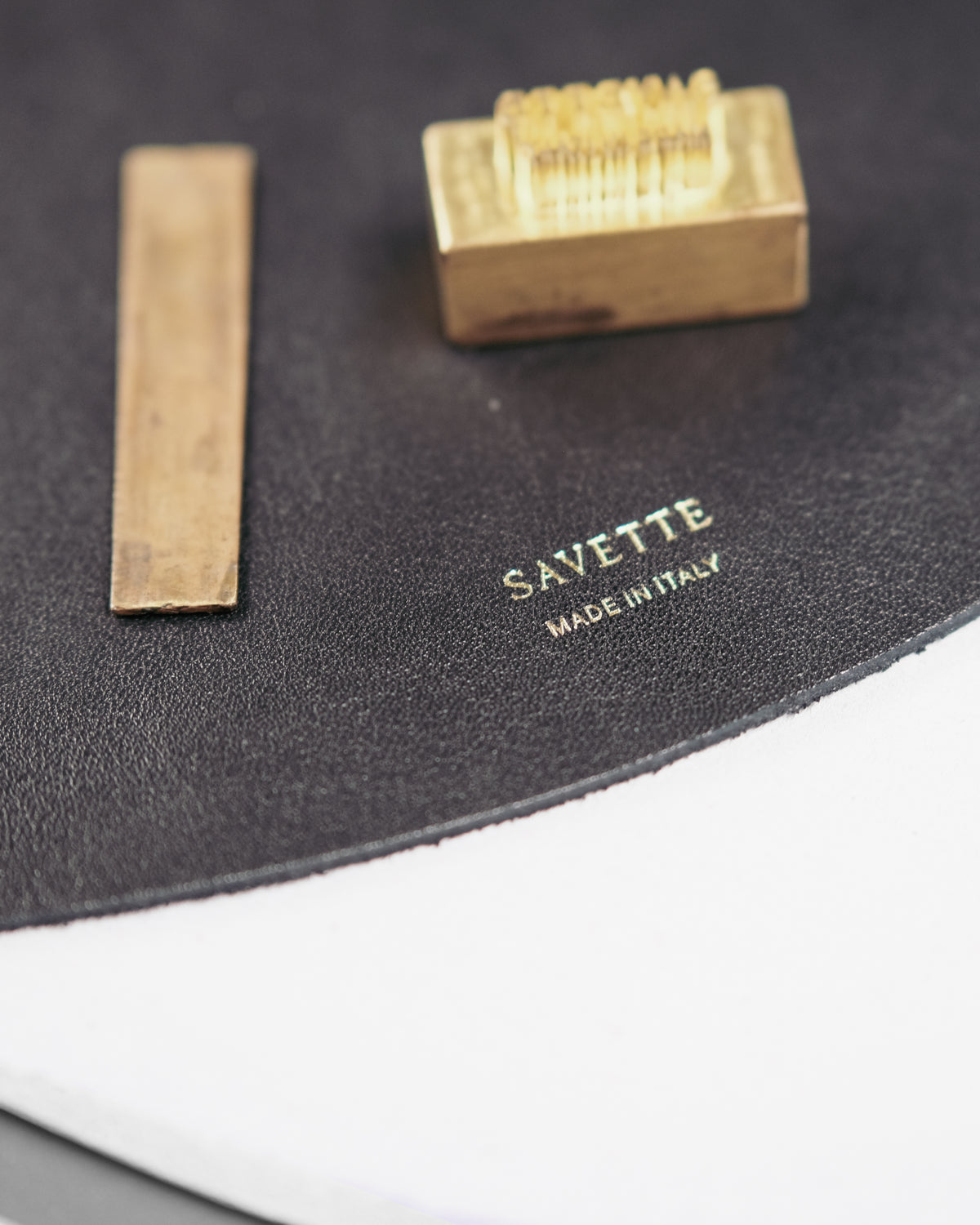 gold hardware pieces placed on black leather bag